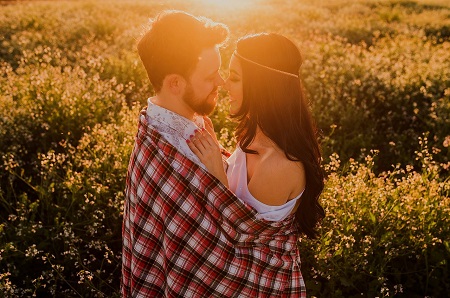 Pareja disfrutando de un picnic romántico en un parque con vista al paisaje